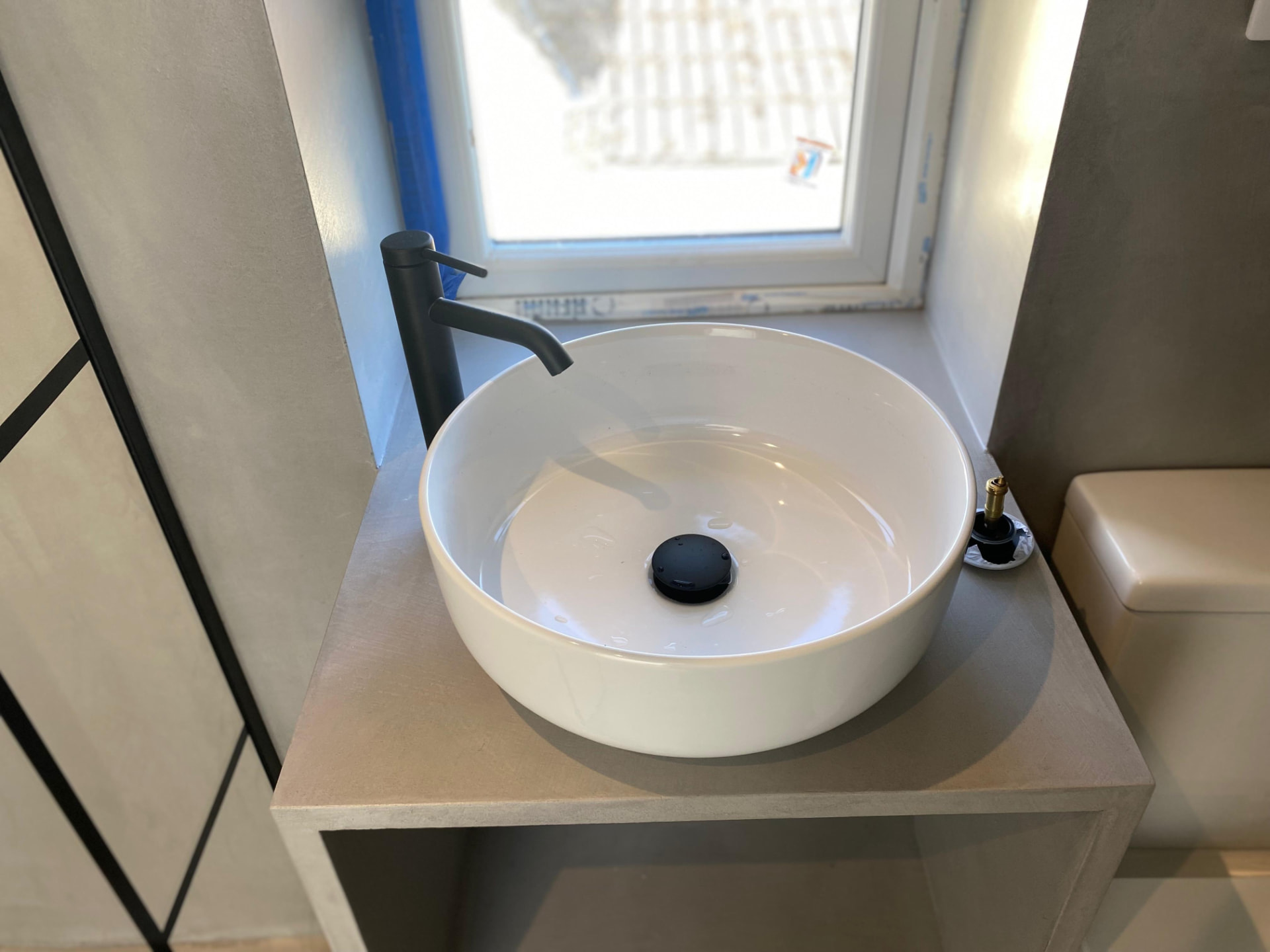 Countertop basin and black tap fitted in a cloakroom