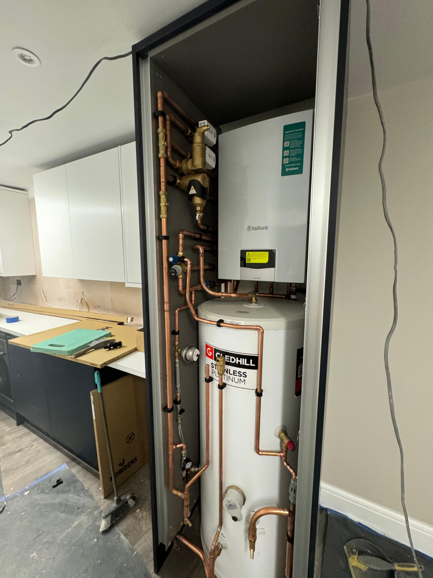 Unvented hot water cylinder and boiler installed in a fitted kitchen cupboard