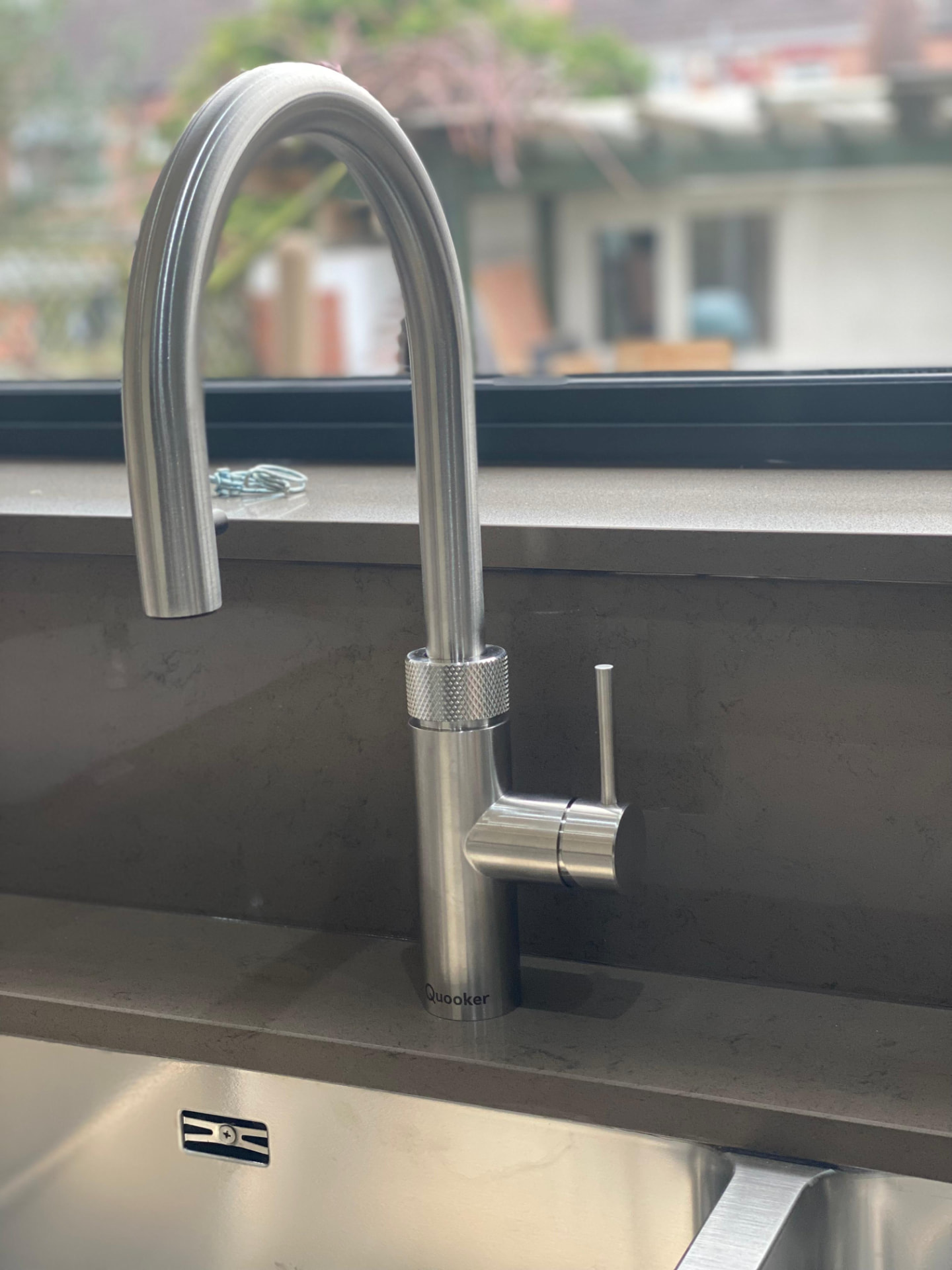 Quooker kitchen tap installed over a stainless steel sink